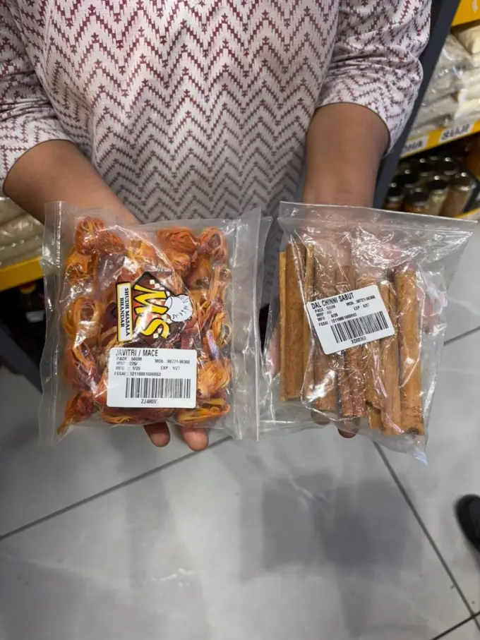 Mittal Spices ke labelled packs haath mein — Javitri aur Dal Chinni Sabut